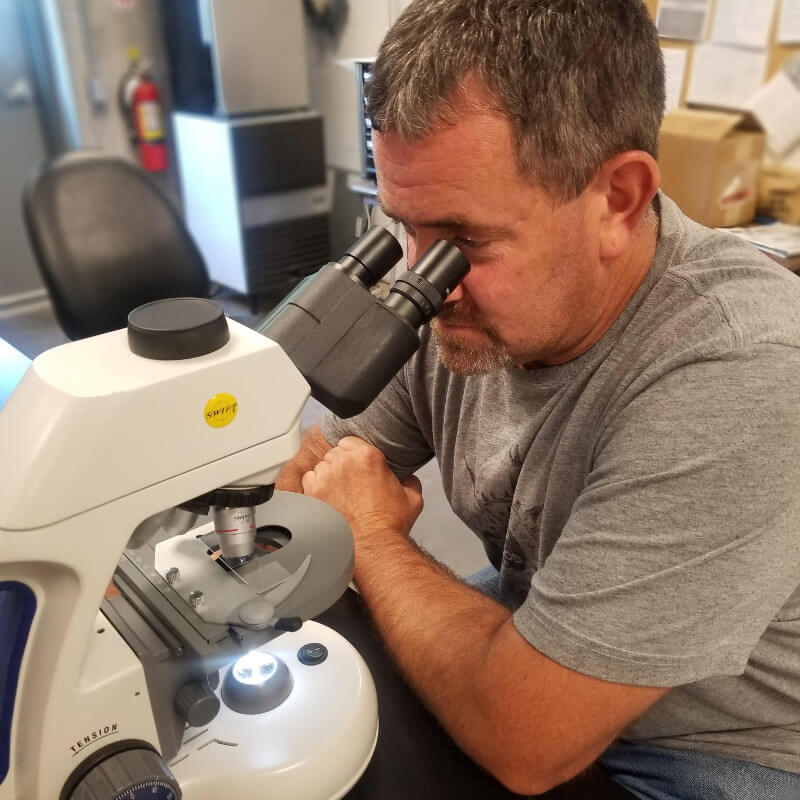 man using microscope